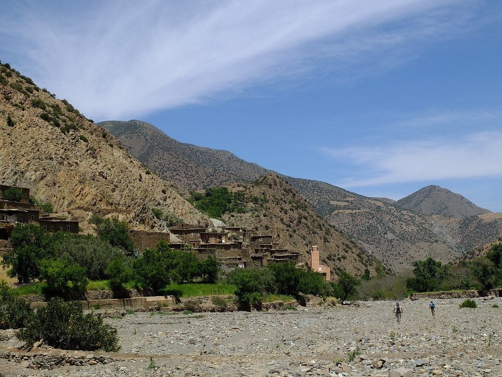 Berber village nestled among the Atlas Mountains beside a dry riverbed