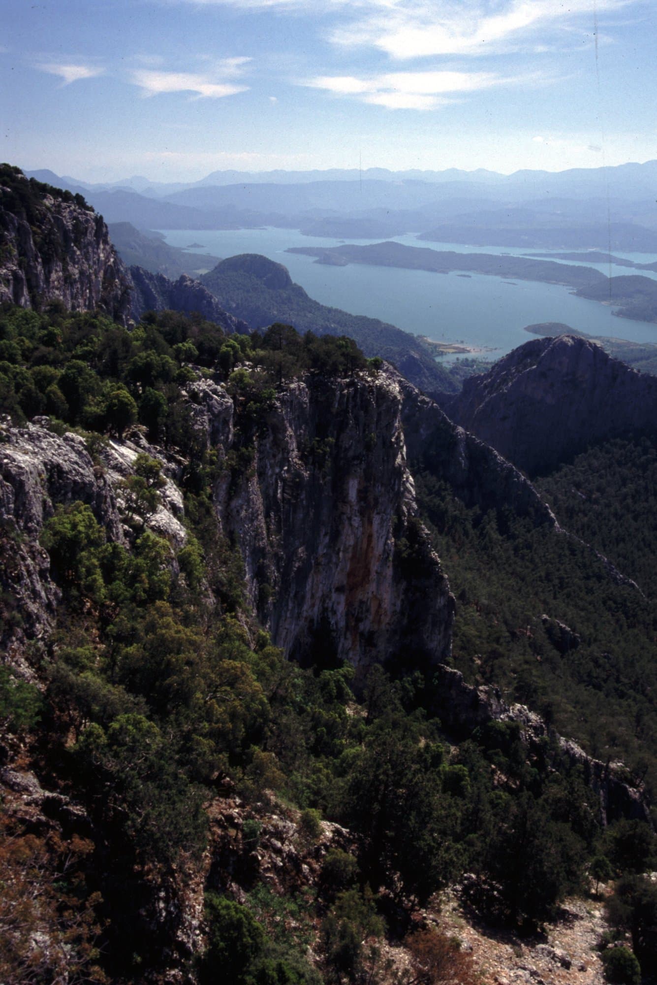 Rocky cliff edge overlooking a distant lake in the Taurus Mountains