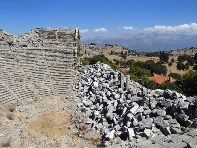 Ancient stone theater ruins scattered across a hillside in the Taurus Mountains