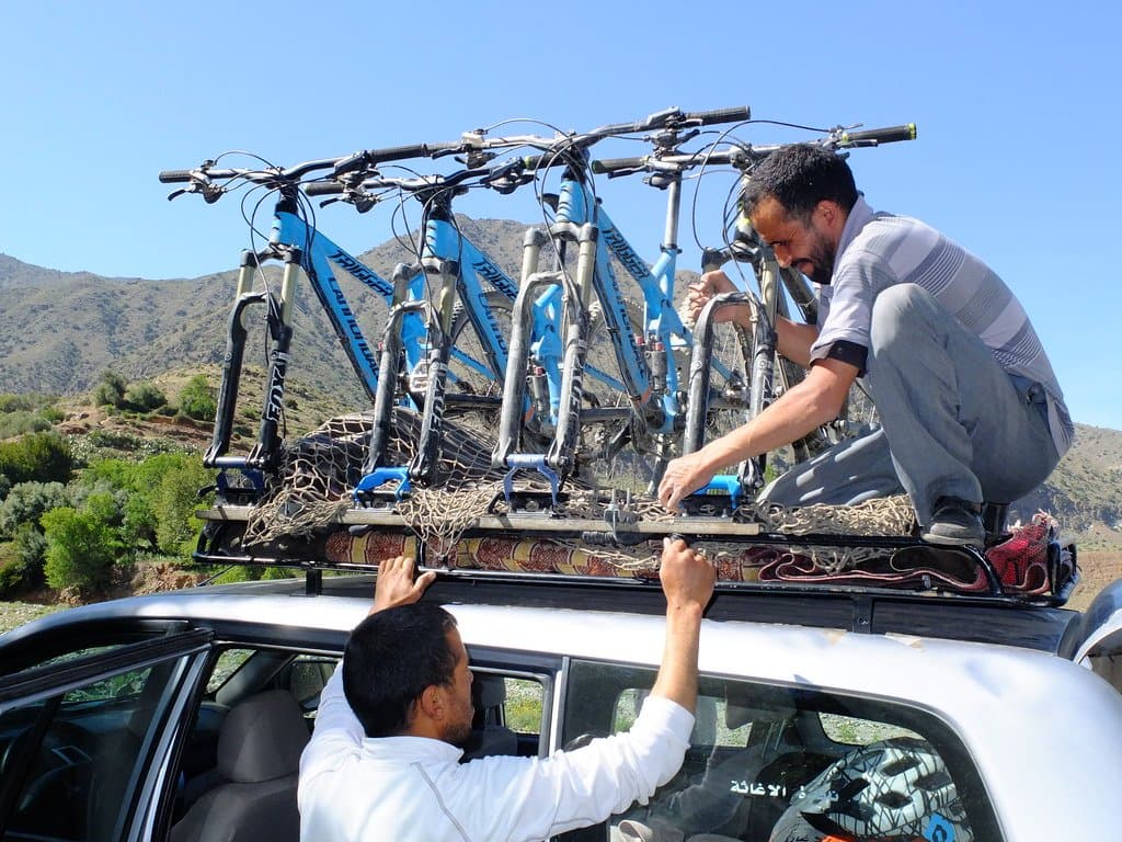 Bikes being loaded onto a car roof rack in the Atlas Mountains, Morocco