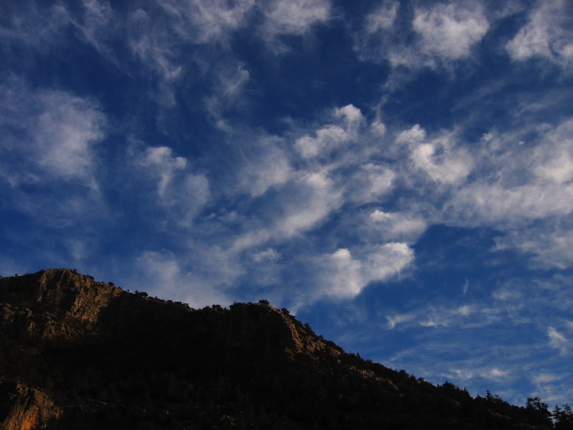 Clouds drifting over a dark mountain ridge silhouette in the Taurus Mountains