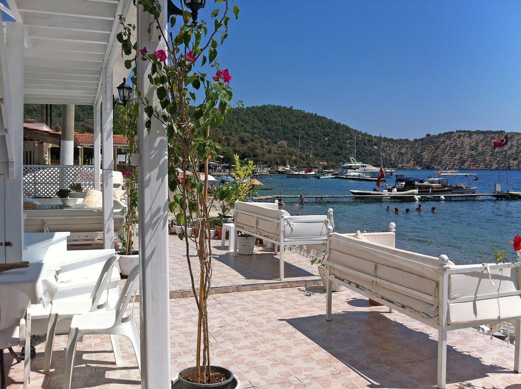 Covered veranda with benches overlooking a marina full of moored boats