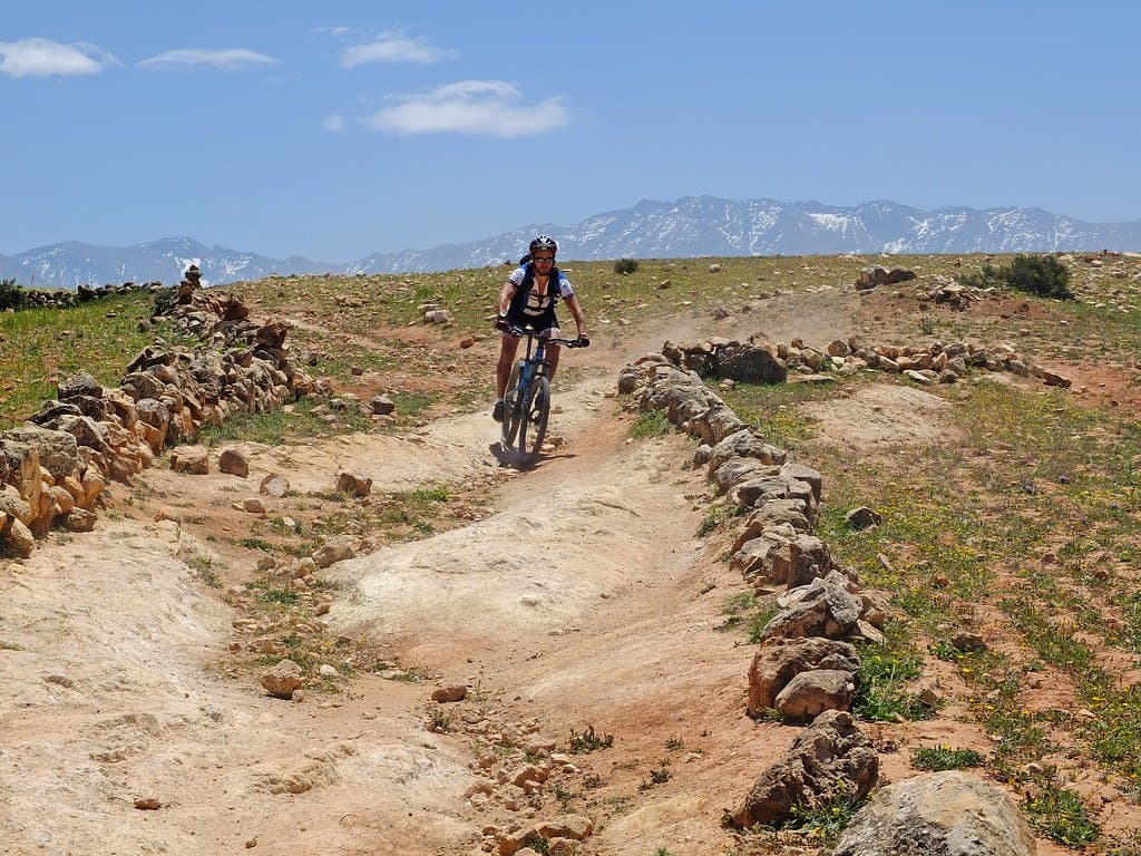 Cyclists riding a stone-walled trail through the Atlas Mountains, Morocco