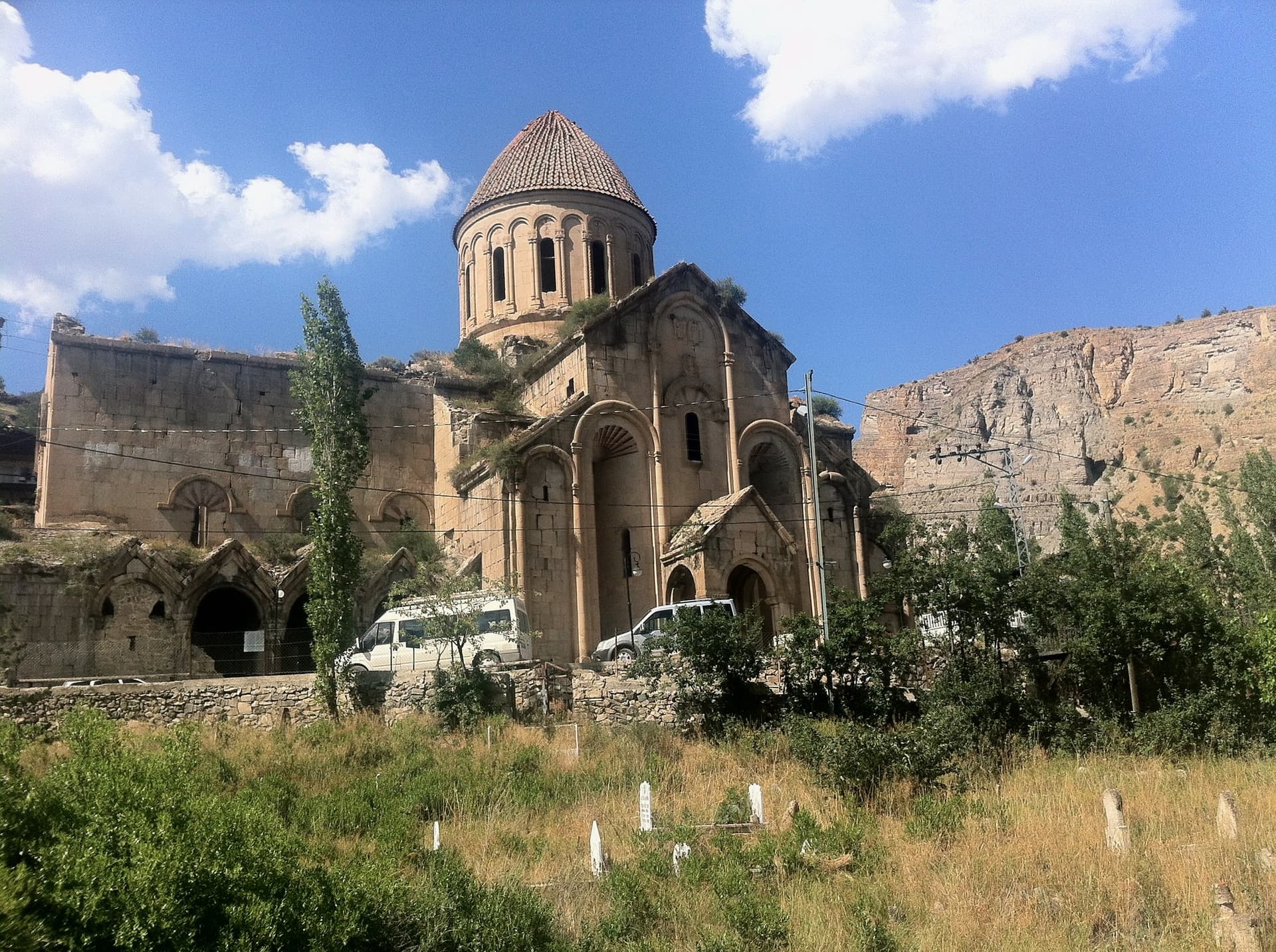 Domed stone church standing against mountains and dry grassland in the Kackar Mountains