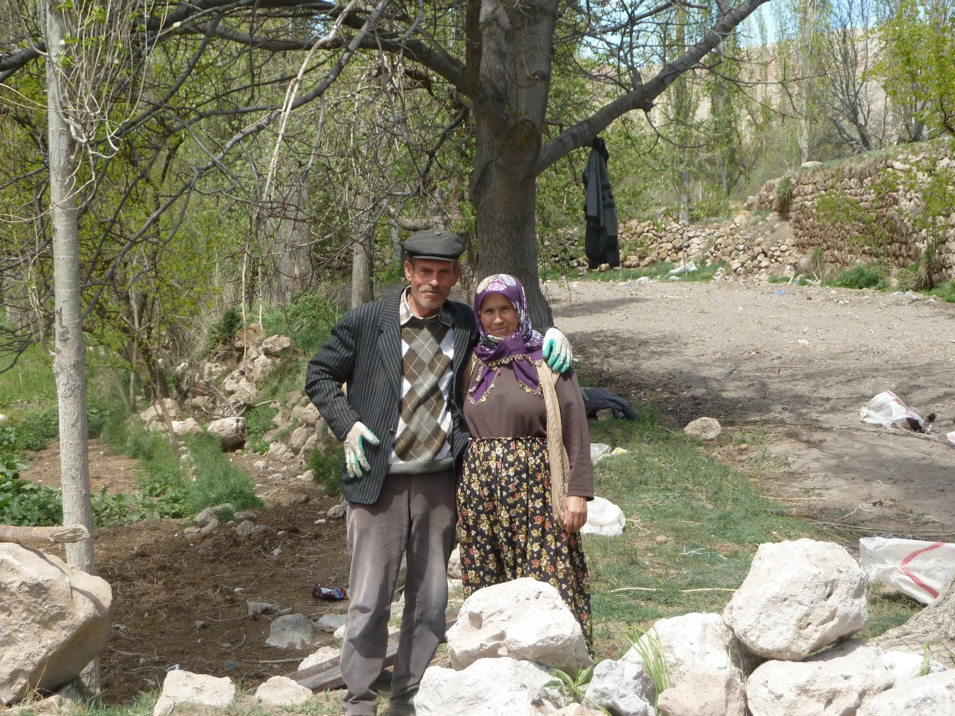 Elderly local couple standing together beside a stone wall in Cappadocia