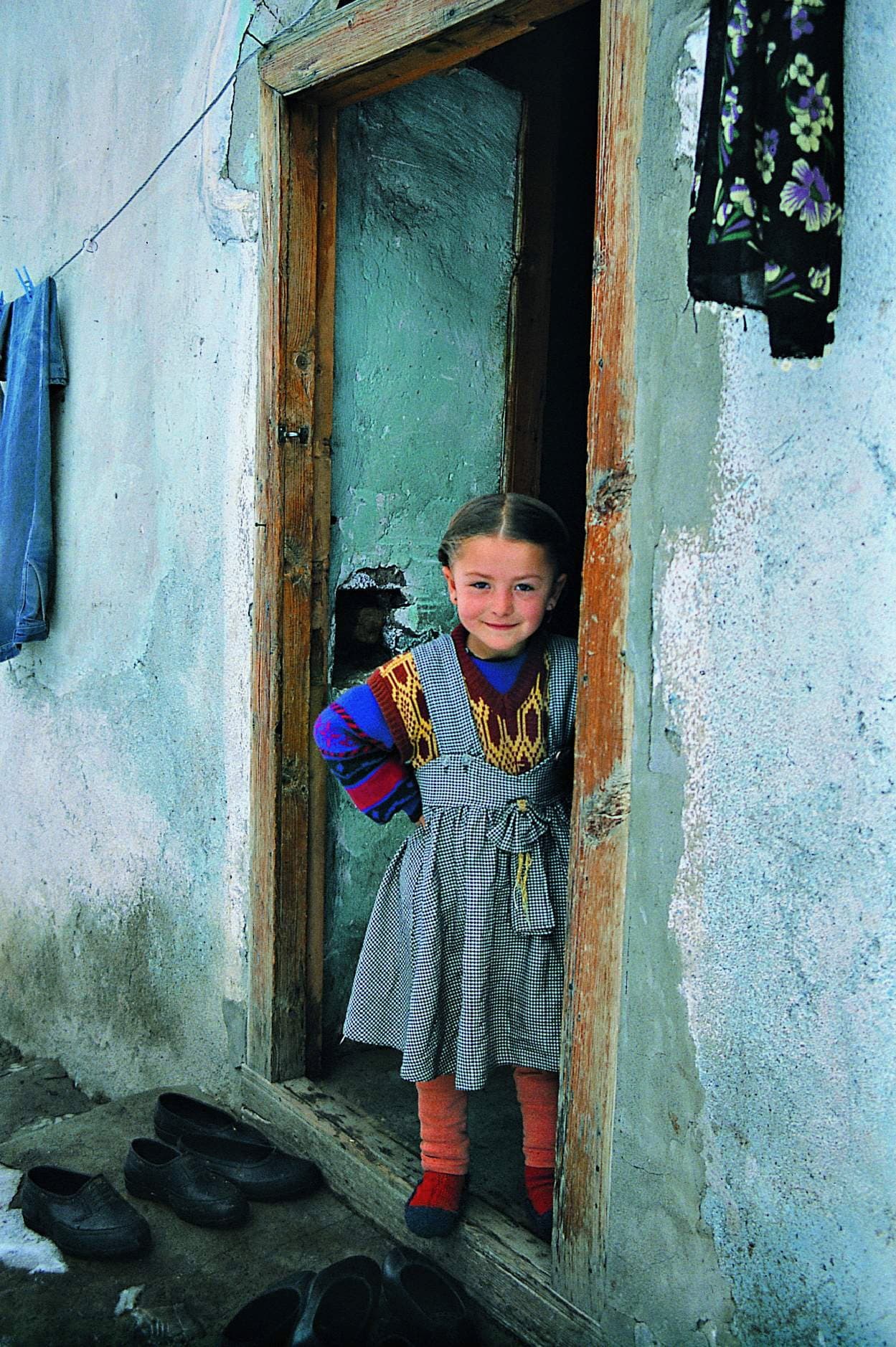 Girl standing in the doorway of a turquoise-painted house in the Kackar Mountains
