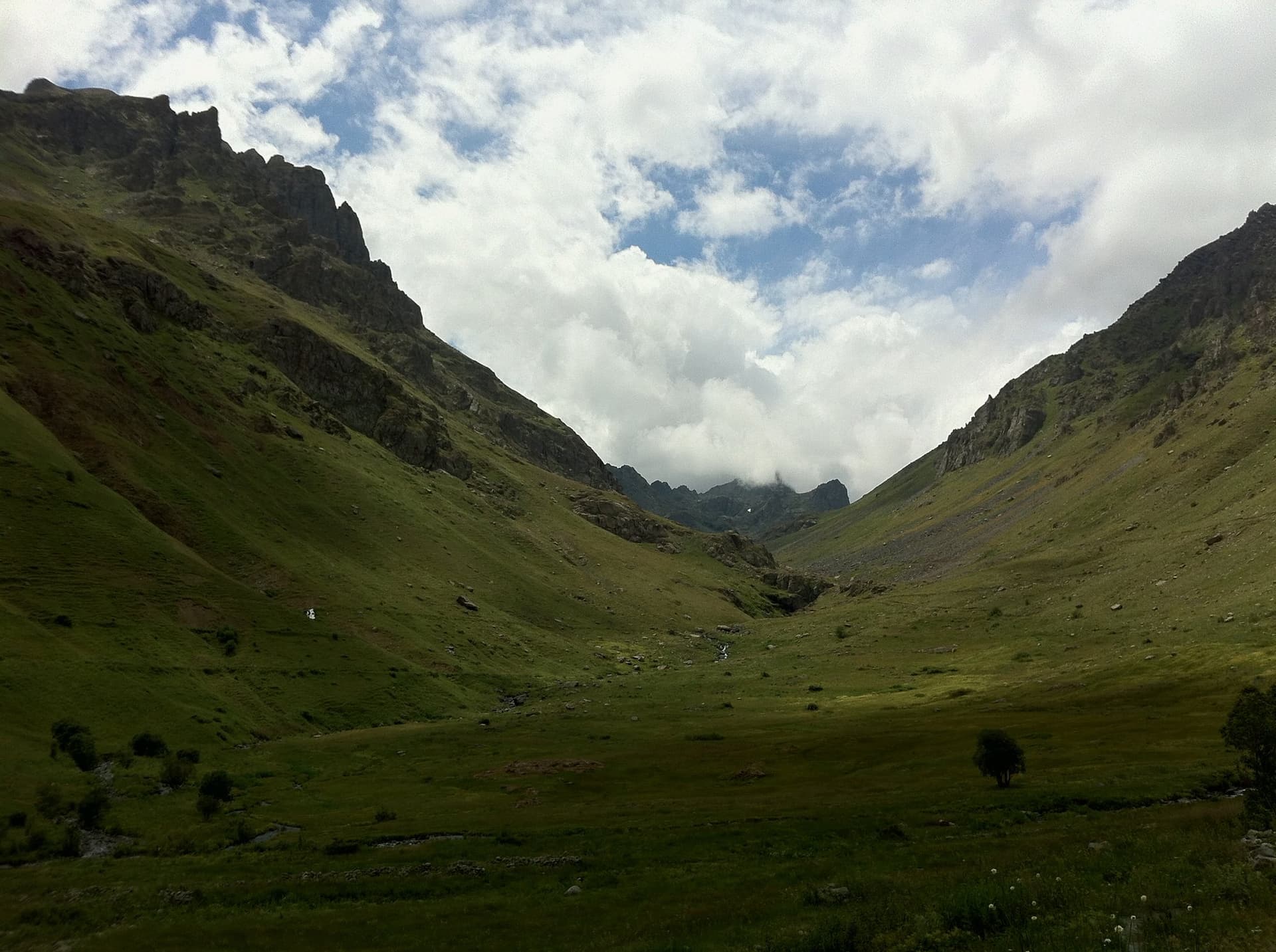 Green valley enclosed by cloud-wrapped ridges in the Kackar Mountains