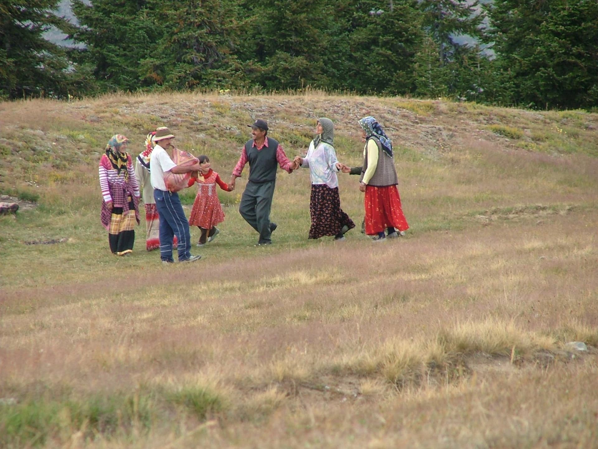 Group in traditional dress dancing in a circle in a Kackar Mountains meadow