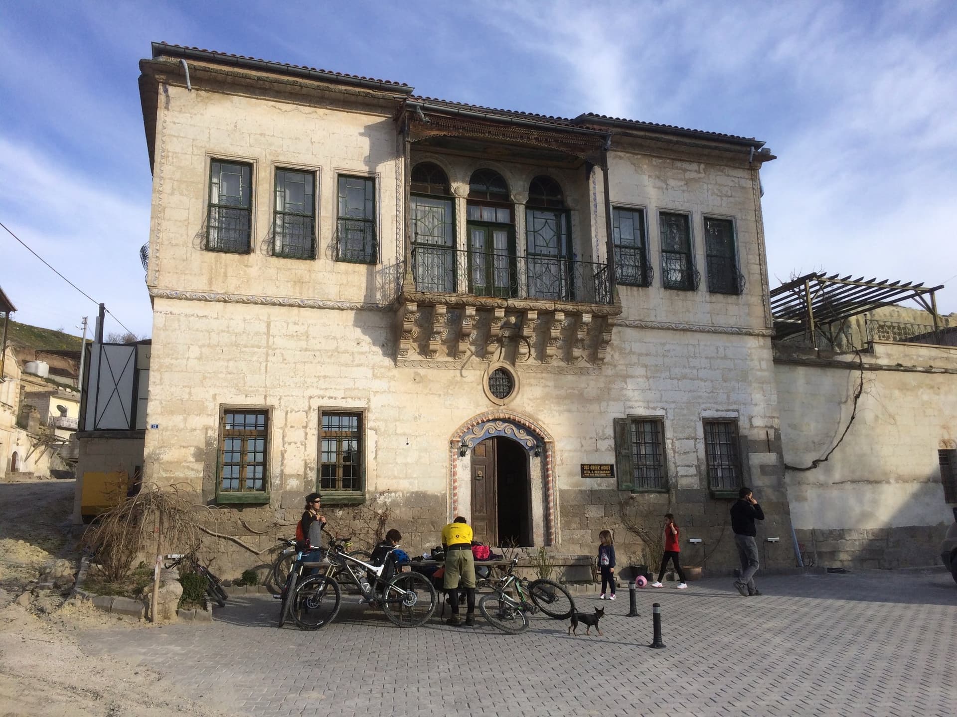 Historic stone mansion with bicycles parked in the square outside in Cappadocia