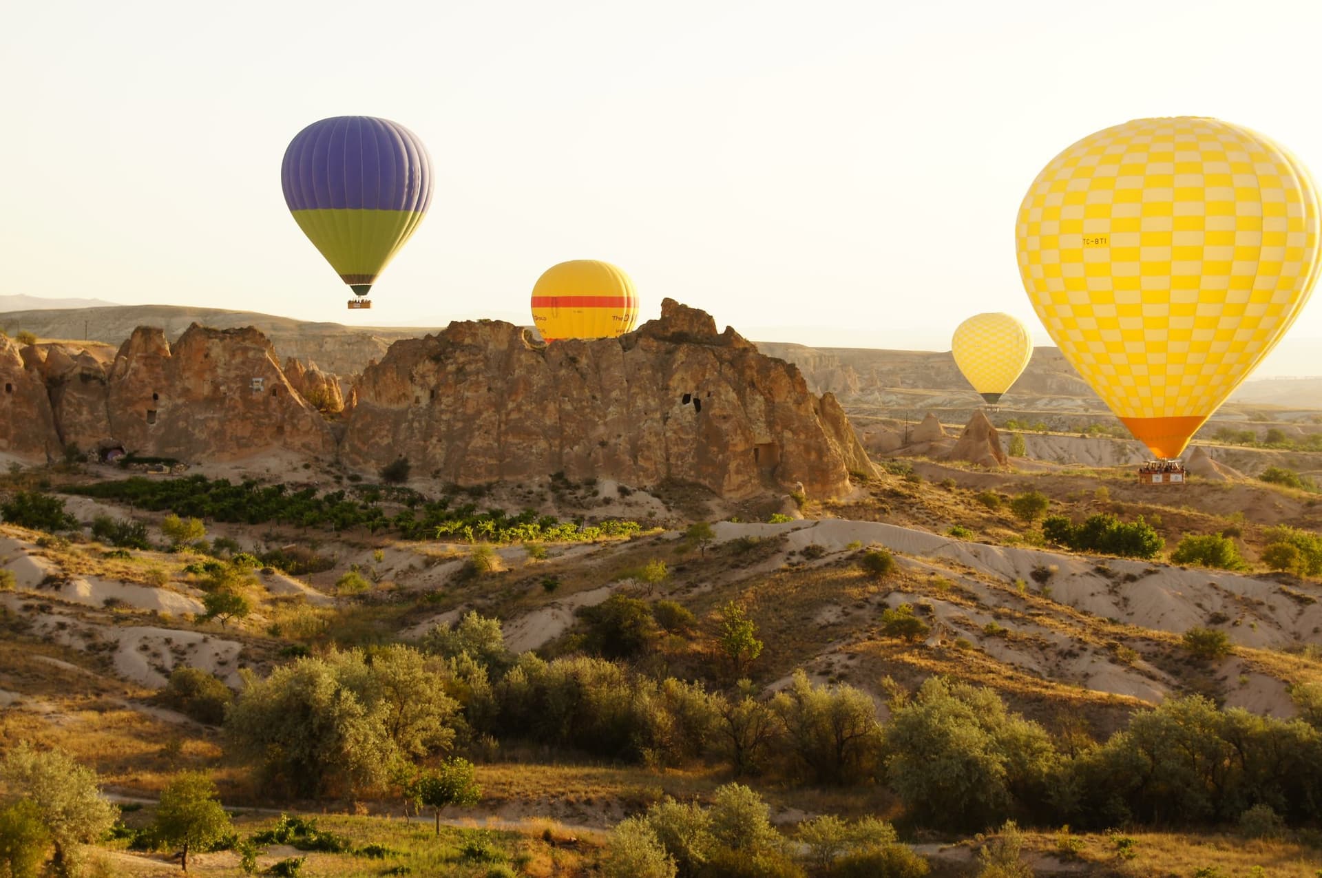 Hot air balloons floating above fairy chimney rock formations in Cappadocia