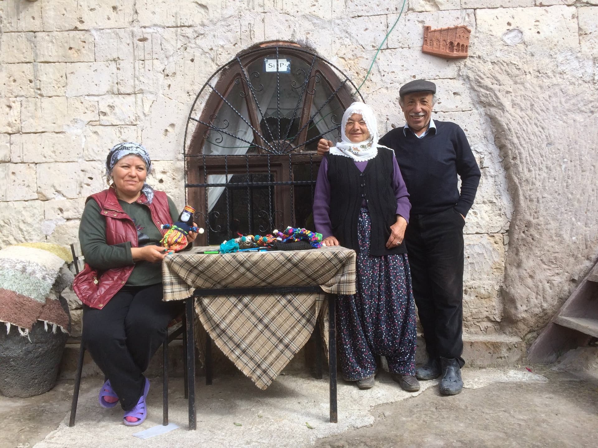 Local women and man with handicrafts displayed on a table in Cappadocia