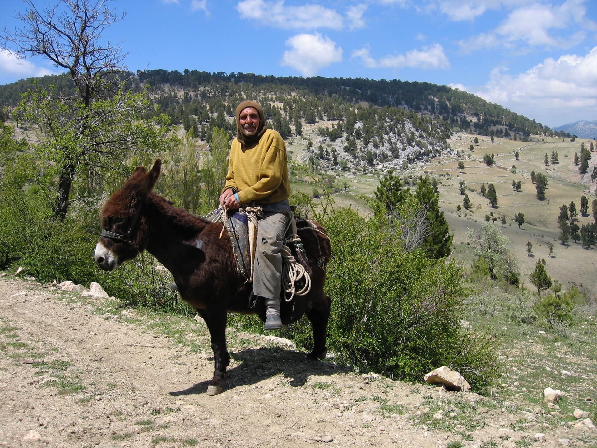 Man riding a donkey along a mountain trail in the Taurus Mountains