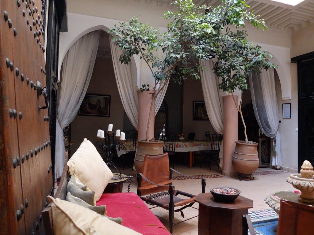 Moroccan riad courtyard with cushioned seating and lantern decor