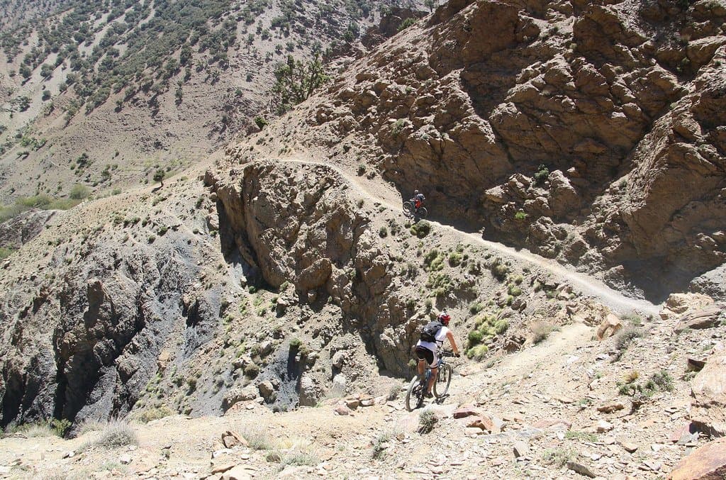 Mountain biker descending a rocky trail through the Atlas Mountains, Morocco