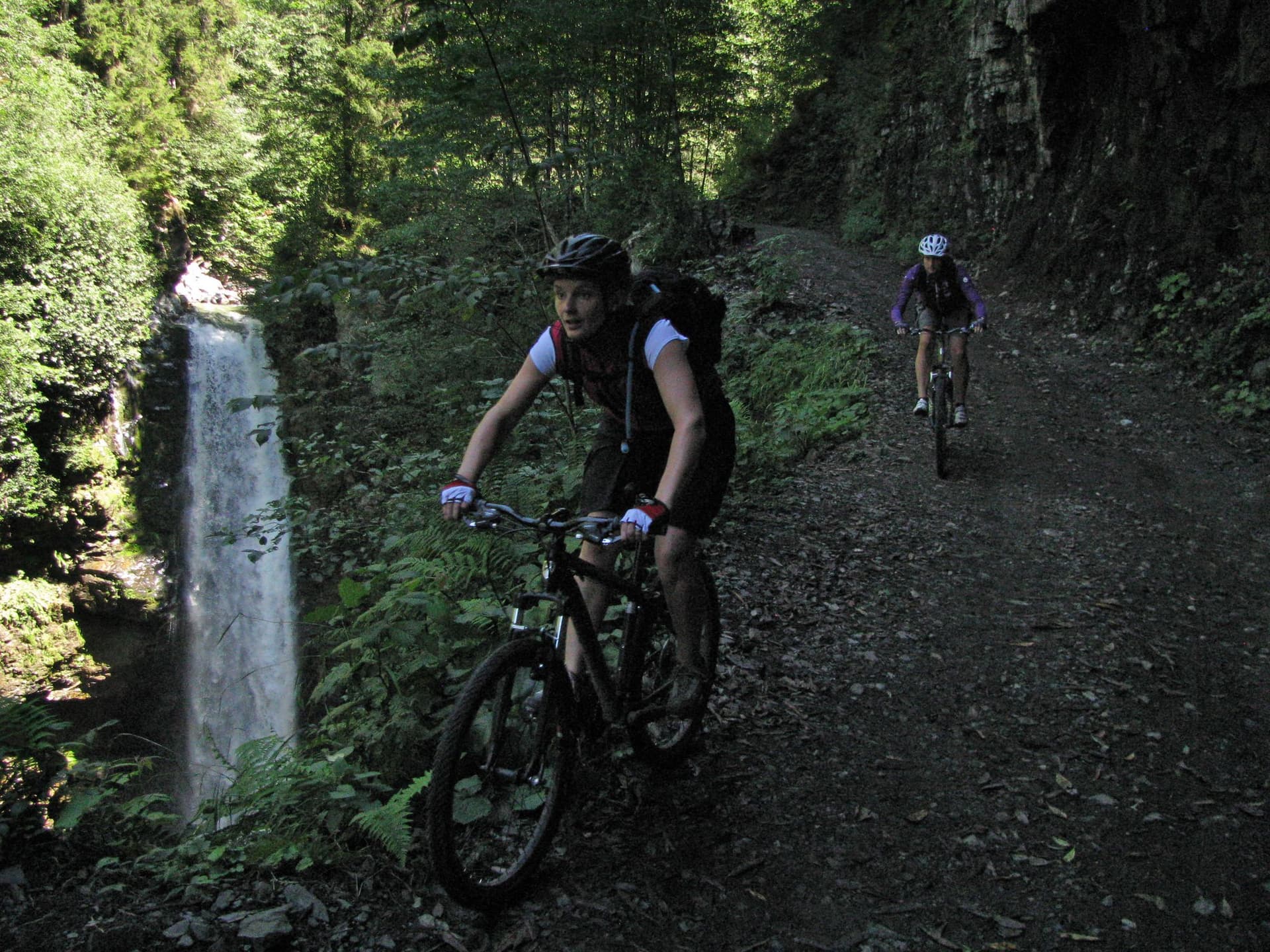 Mountain biker riding a forest trail past a waterfall in the Kackar Mountains