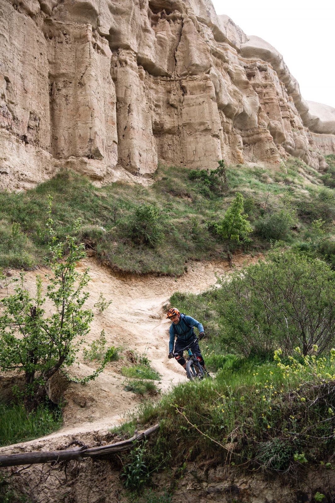 Mountain biker riding a narrow trail between tall rock walls in Cappadocia