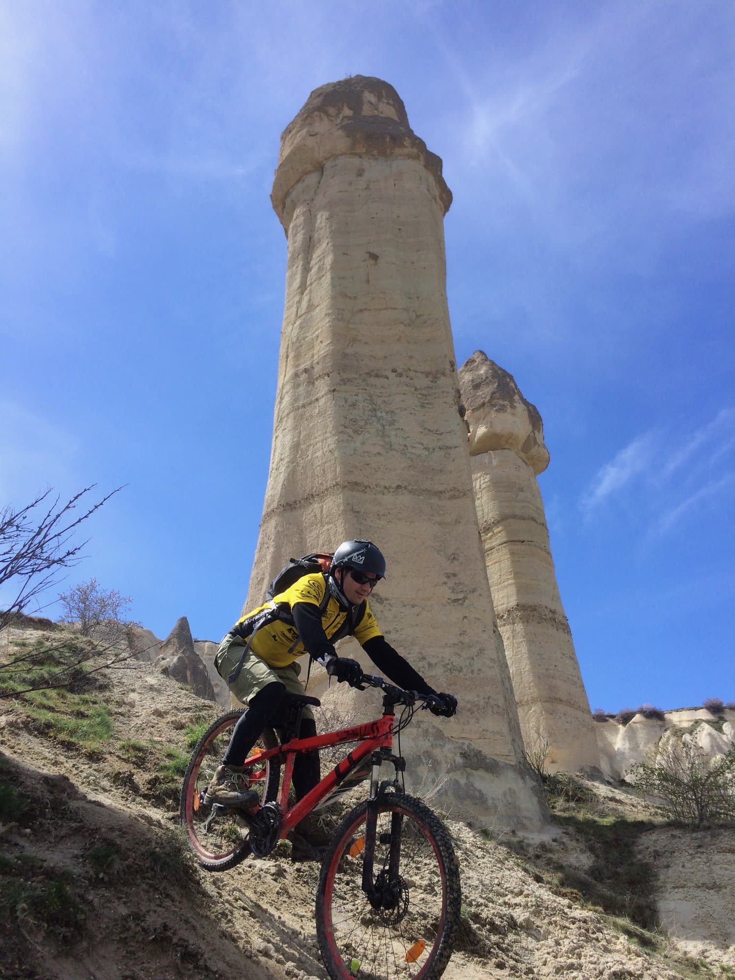 Mountain biker riding past twin fairy chimney rock towers in Cappadocia