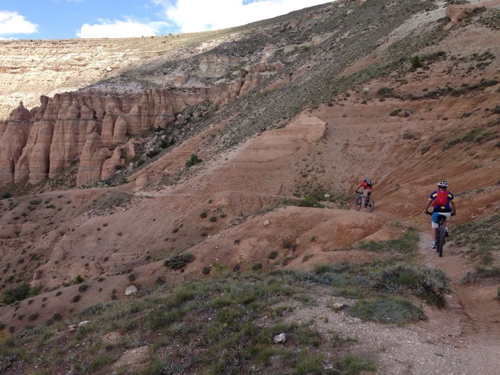 Mountain bikers descending a red rock canyon trail in Cappadocia