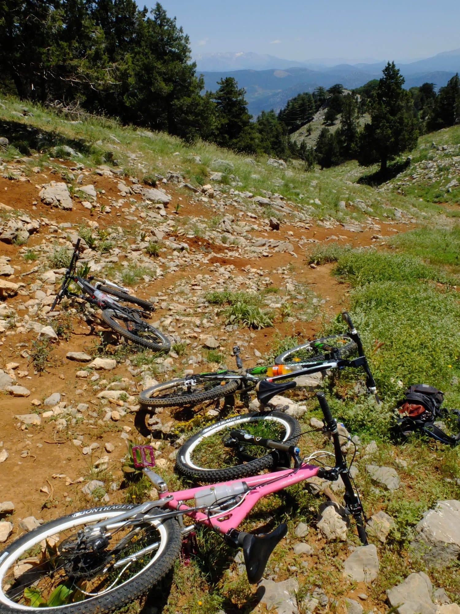 Mountain bikes piled together on a grassy slope in the Taurus Mountains
