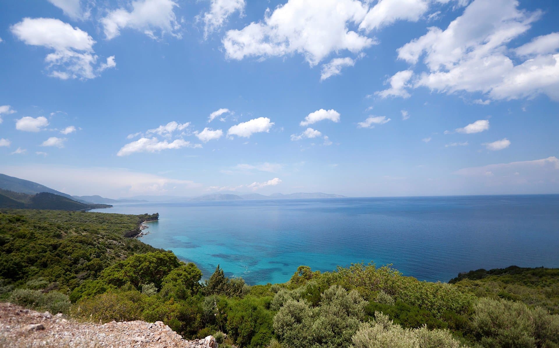 Panoramic view of a turquoise bay from a rocky coastal headland