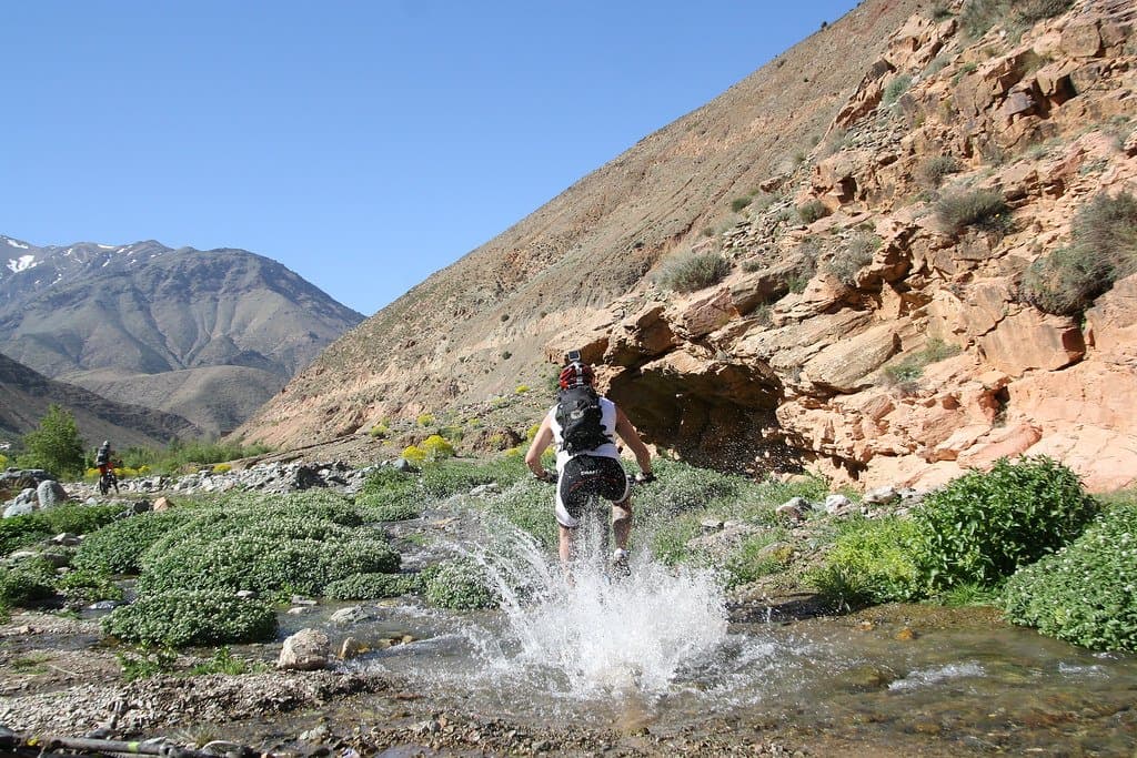 Person wading through a splashing mountain stream in the Atlas Mountains, Morocco