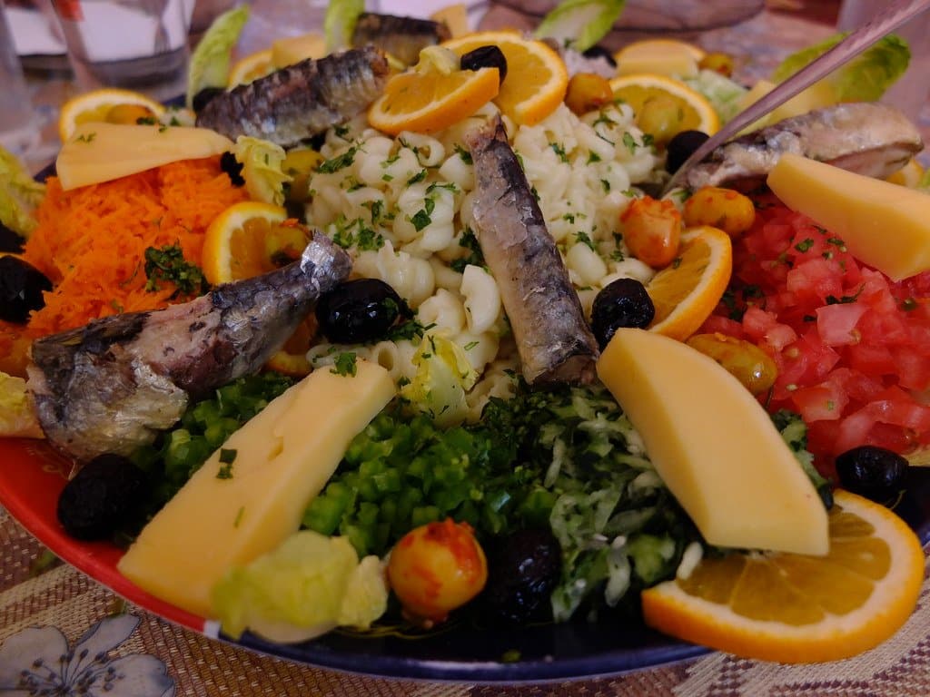 Plate of grilled sardines, rice, olives and orange slices, a Moroccan dish