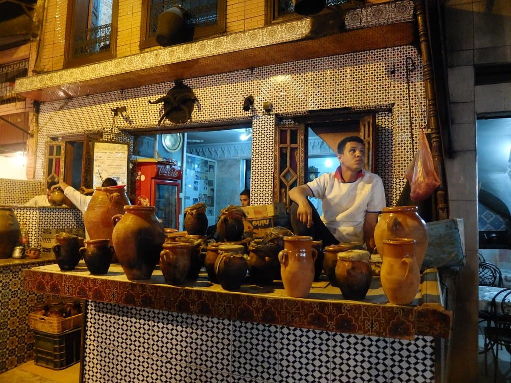 Pottery jars displayed at a lantern-lit market stall in Morocco