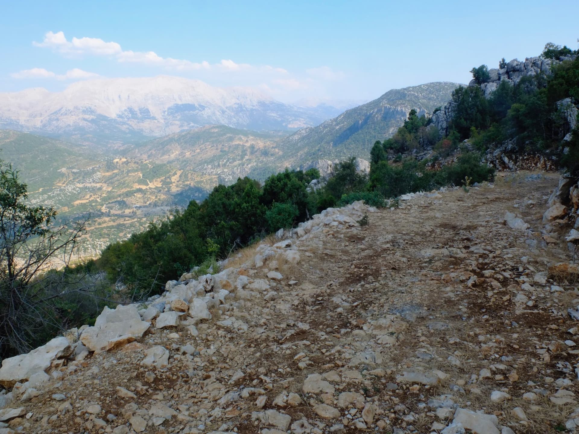 Rocky trail hugging a ridge above hazy Taurus Mountains peaks