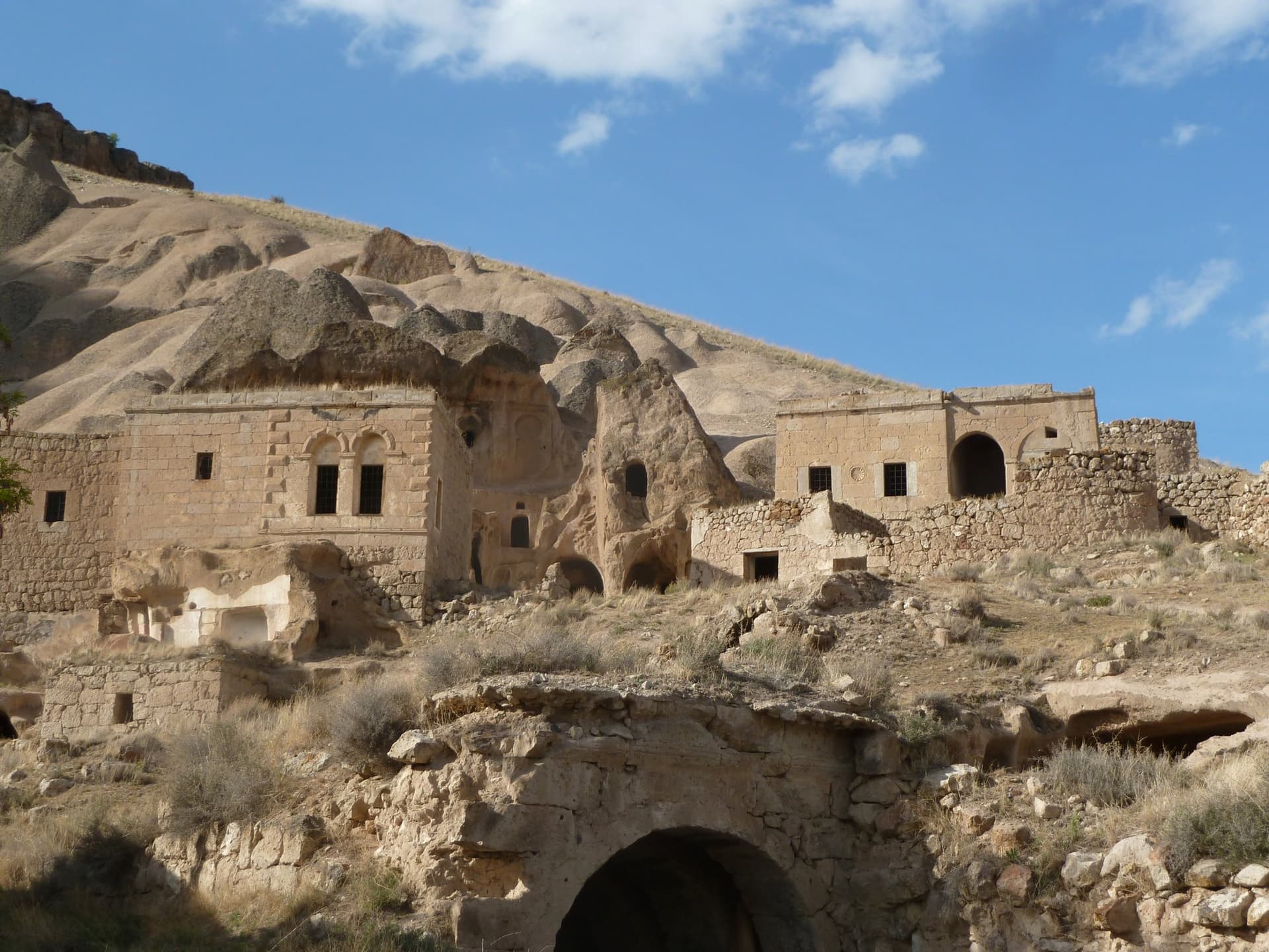 Stone buildings and cave dwellings built into a Cappadocia hillside