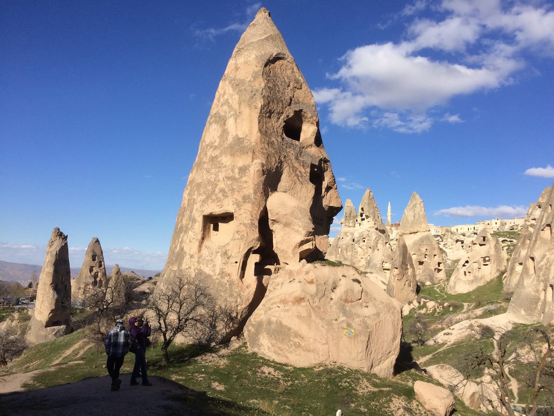 Tall fairy chimney rock formation with carved cave openings in Cappadocia
