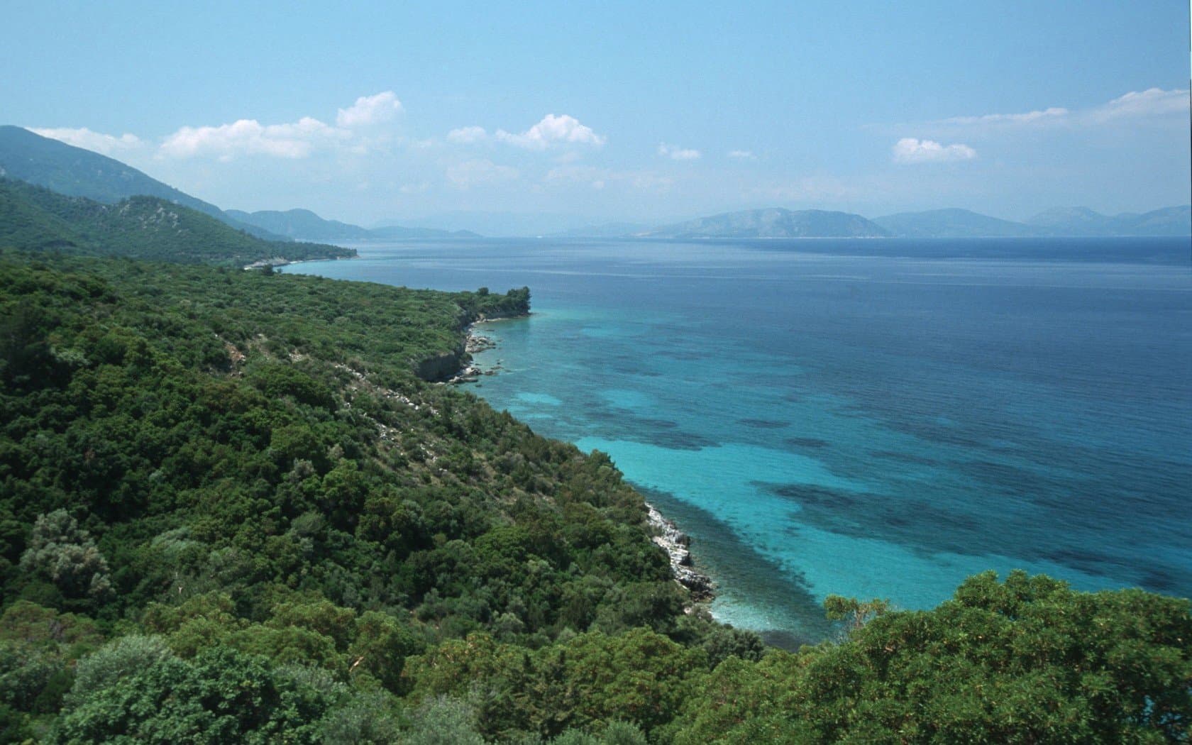Turquoise shallows and pine-covered headland on Turkey's Aegean coast