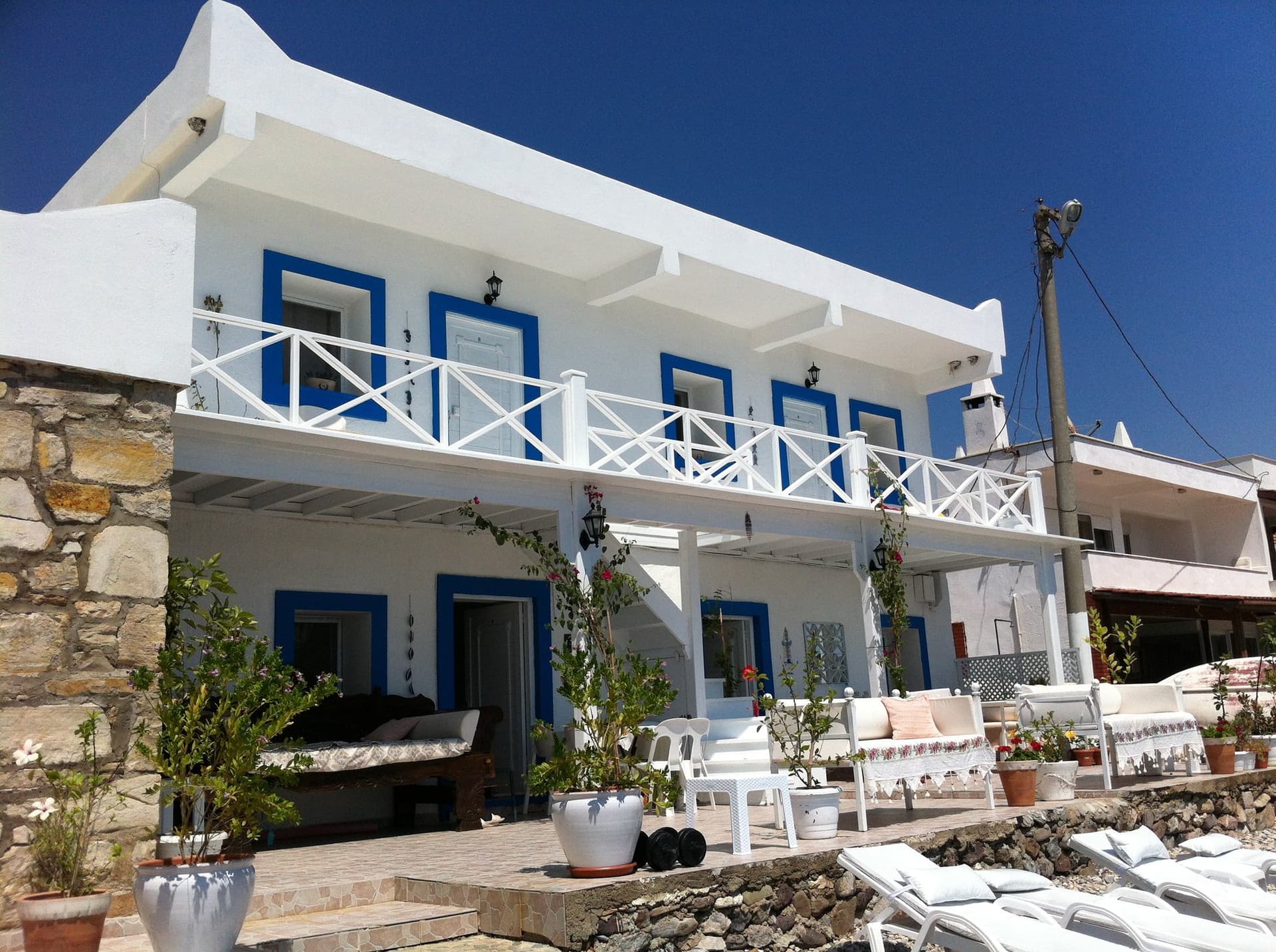 White and blue hotel building with balconies and sun loungers