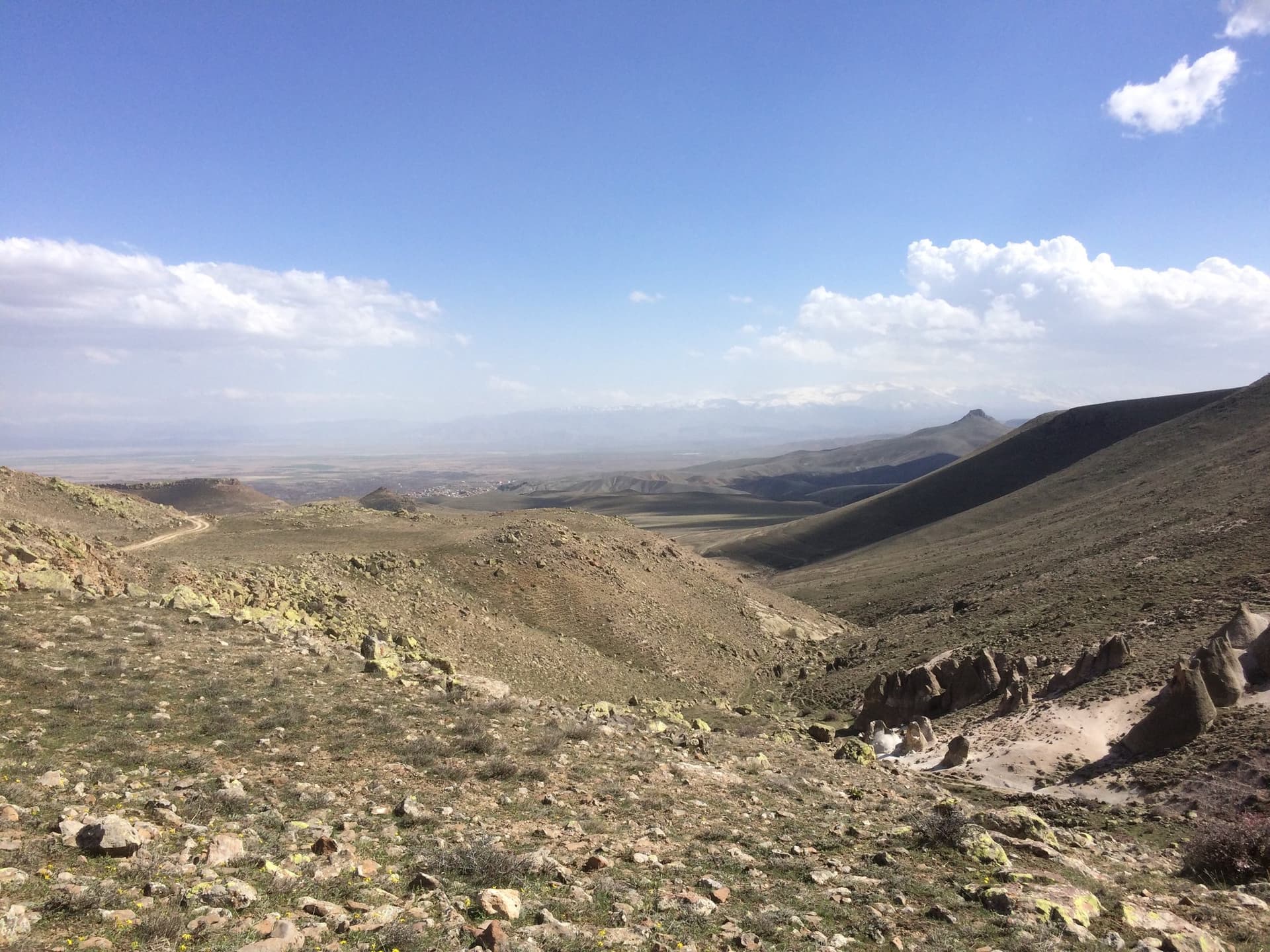 Wide barren valley of eroded hills stretching to the horizon in Cappadocia