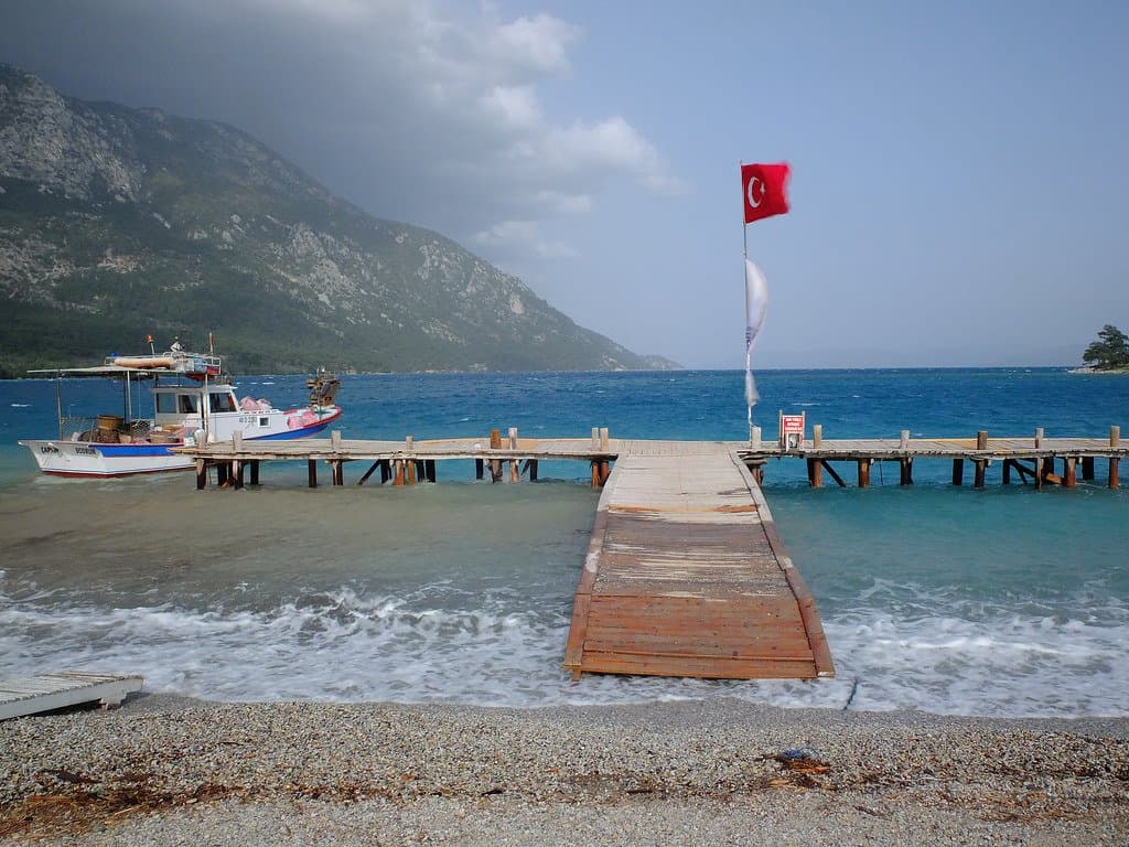 Wooden jetty with a Turkish flag leading out into the Aegean Sea